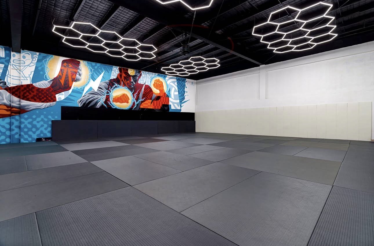 Competition mat space with the academy's hero mural