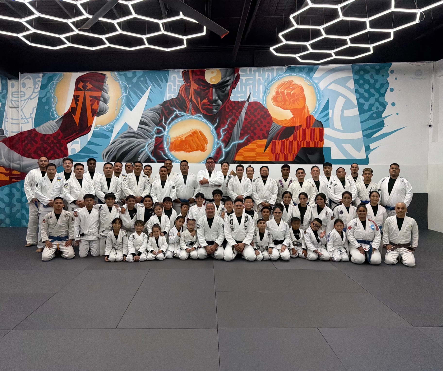 Guam Martial Arts Academy group photo in front of the mural